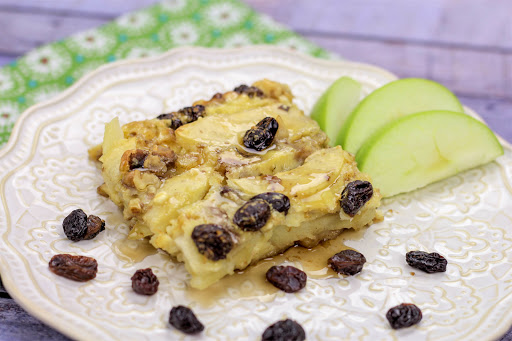 A slice of Apple Puff Pancakes on a plate with raisins.