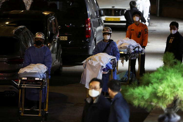 People move bodies to be transported from hospital, after a stampede during a Halloween festival in Seoul, South Korea, October 30, 2022.