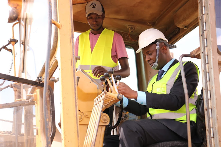 Murang'a Governor Irungu Kang'ata steering an earth mover in Kangari town during the launch of Smart Cities.