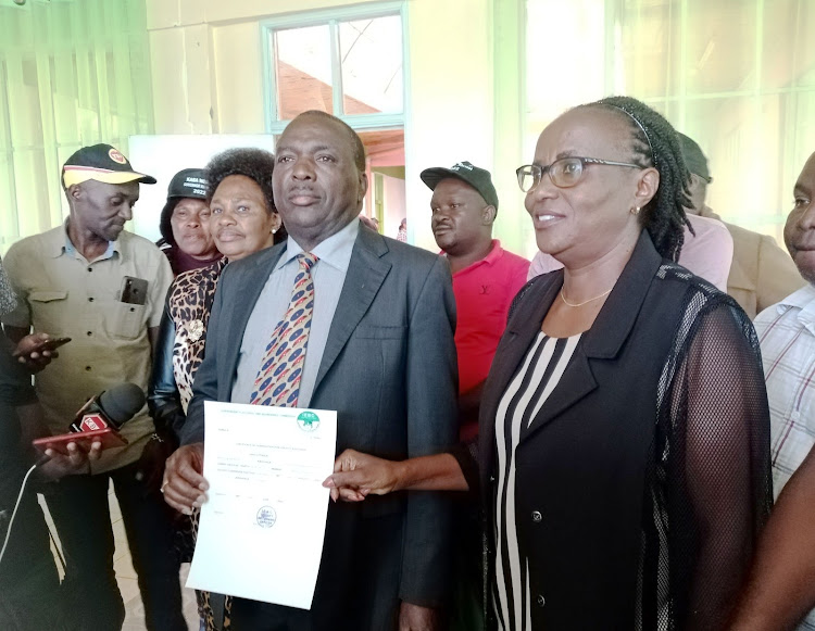 Former Kirinyaga Governor Joseph Ndathi and his running mate Dr Judy Kinyua display their certificate after the IEBC cleared them