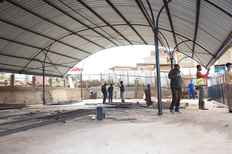 Workers at the Sh32 million Kanyenya-ini market that is 93 percent done.