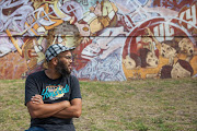 Designer and graffiti artist Quasiem Gamiet in front of the “Cape of Styles” wall in Salt River.