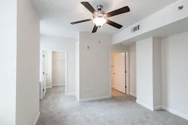 Bedroom with neutral carpet, light walls, white trim, and a ceiling fan