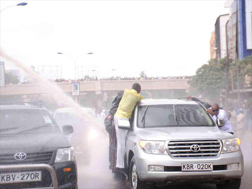 A water canon sprays Cord leader Raila Odinga's car with water during anti-IEBC protests on Monday Photo/Patrick Vidija