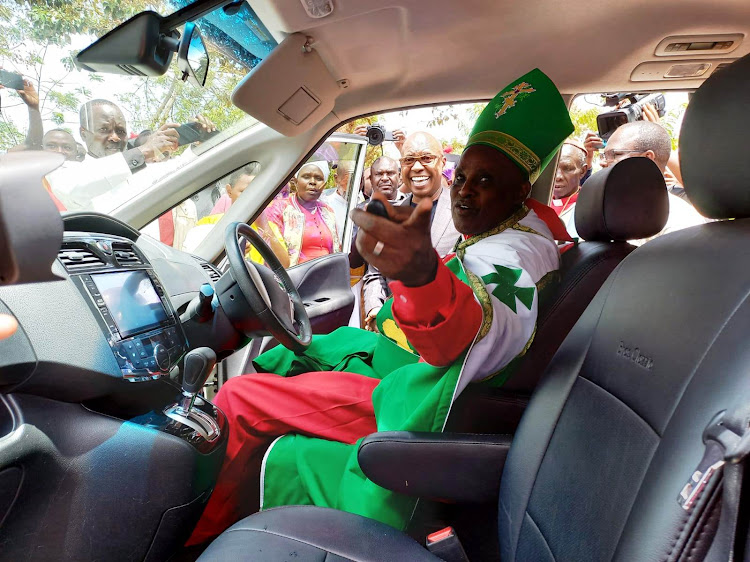 AIPCA Kutus bishop Peter Mwangi tries out his newly delivered car gift by Safina presidential hopeful Jimmy Wanjigi.