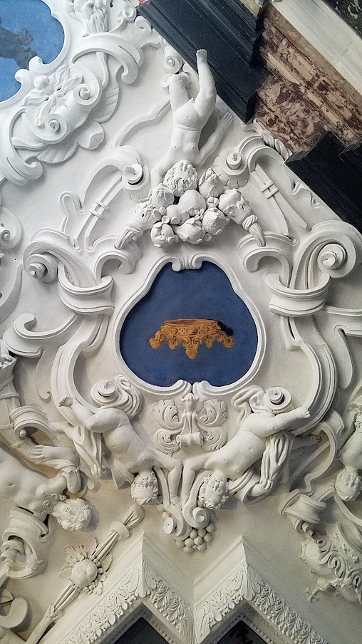 Visiting Rosenborg Castle in Copenhagen. This is the Marble Room - the ceiling paintings also show small, chubby, angelic child figures, carrying the Regalia and in the heart-shaped areas surrounding the paintings you can see parts of the Danish coat-of-arms and on the wall are the emblems of Norway, Denmark, and Sweden.