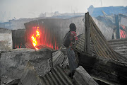 A resident watches as his shack goes up in smoke     in Alexandra, Johannesburg,  yesterday. / Veli Nhlapo