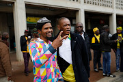 Ace Magashule takes a picture with a member of the community in Kliptown. 