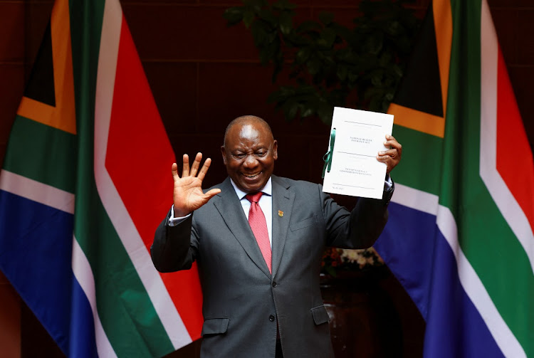 President Cyril Ramaphosa gestures after signing into law the NHI Bill.