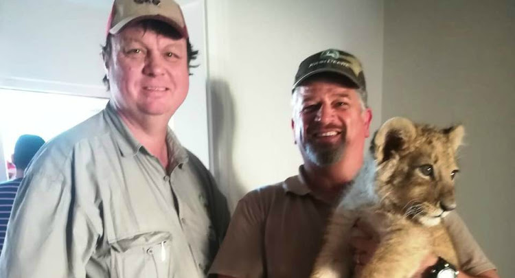 Warrant officers HS Schroeder and AJ van Greunen of the police's stock theft unit with the lion cub they rescued in Athlone, Cape Town, on August 21 2019. It had apparently been transported from Limpopo.