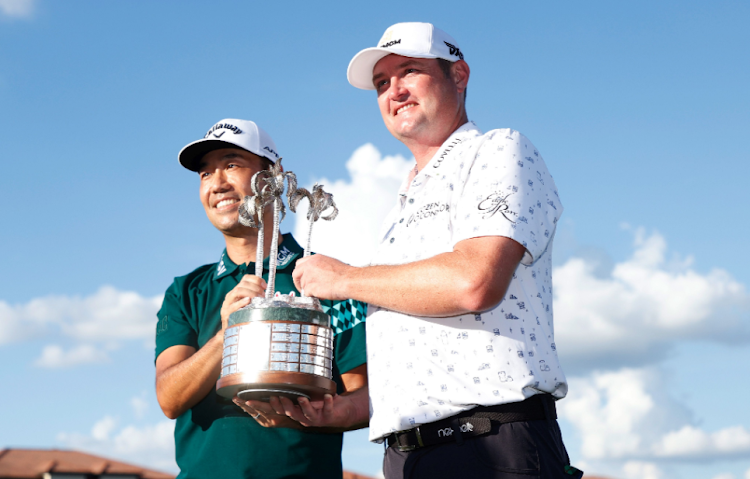 Jason Kokrak and Kevin Na, both of the US, celebrate with the trophy on the 18th green after winning the QBE Shootout on Sunday at Tiburon Golf Club in Naples. Picture: GETTY IMAGES/CLIFF HAWKINS