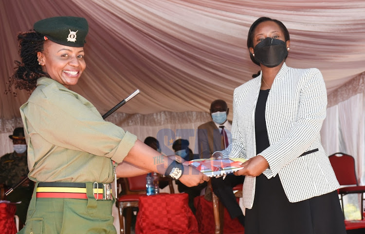 ICT CAS Maureen Mbaka awards Langata women's prison Senior Sergeant Susan Marita with a graduation certificate at KFC school on September 29, 2021. PHOTO/MERCY MUMO