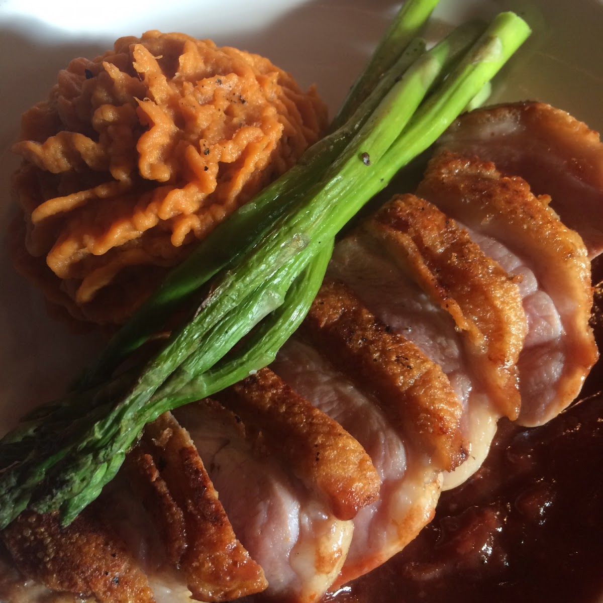 Seared duck breast with sweet potato mash, asparagus, and a red wine reduction.