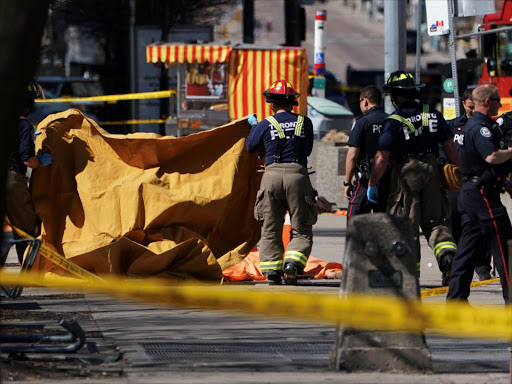 Firemen cover a victim of an incident where a van struck multiple people at a major intersection in Toronto's northern suburbs, in Toronto, Ontario, Canada, April 23, 2018. /REUTERS