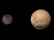 In this handout provided by the National Aeronautics and Space Administration (NASA), the dwarf planet Pluto (R) and Charon are shown. Getty Images/AFP