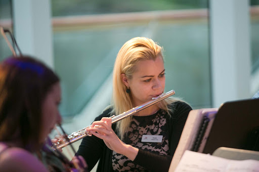 Evelin, the flutist in a classical trio, performs in the Explorers' Lounge on a Viking ocean voyage.