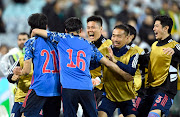 Japan's Kaoru Mitoma celebrates scoring their second goal with teammates.