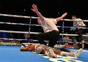 Siboniso Gonya lies flat on the canvas from Zolani Tete's lightning hook as referee Phil Edwards waves the fight over in Belfast. /Charles McQuillan/Getty Images