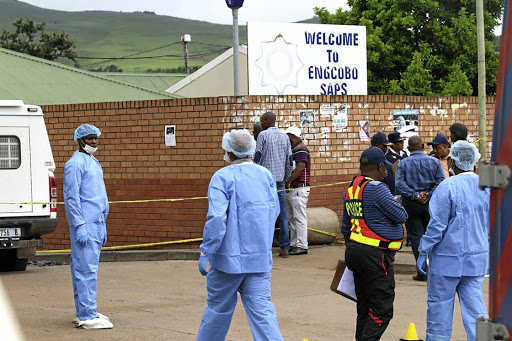 Police forensic investigators work the scene at the Engcobo police station.