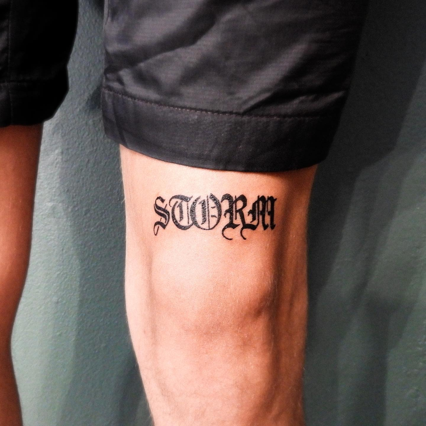 Guy shows off his name print knee cap tattoo