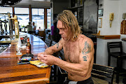 Donovan Kane rolls a cigarette at the Hotel Glencairn in Cape Town.