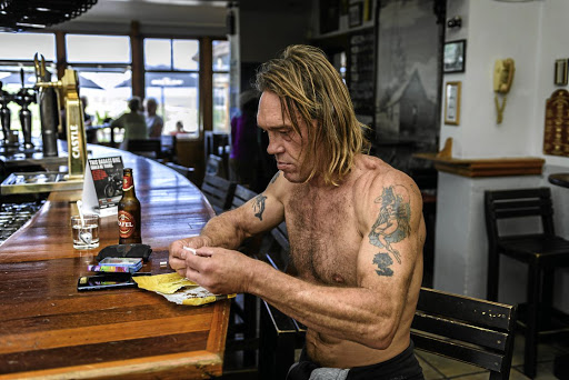 Donovan Kane rolls a cigarette at the Hotel Glencairn in Cape Town.