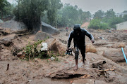 A man walks away from buildings damaged by Cyclone Freddy near Blantyre, Malawi, on March 13 2023.