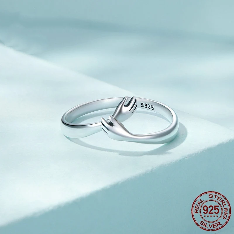 Anillo de plata de ley S925 con diseño de abrazo cruzado a dos manos, simbolizando amor y conexión eterna, perfecto para regalo.