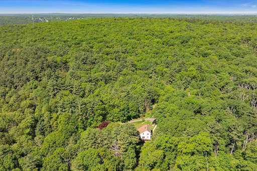 White house amid lush woods in this luxury house for sale in Upton ($600,000)