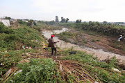 Community leader Lucas Modisa looks at a river that burst its banks after heavy rains. File photo.