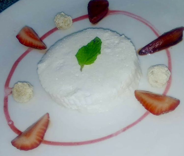 A yogourt parfait garnished with strawberry slices and sugar coated almonds