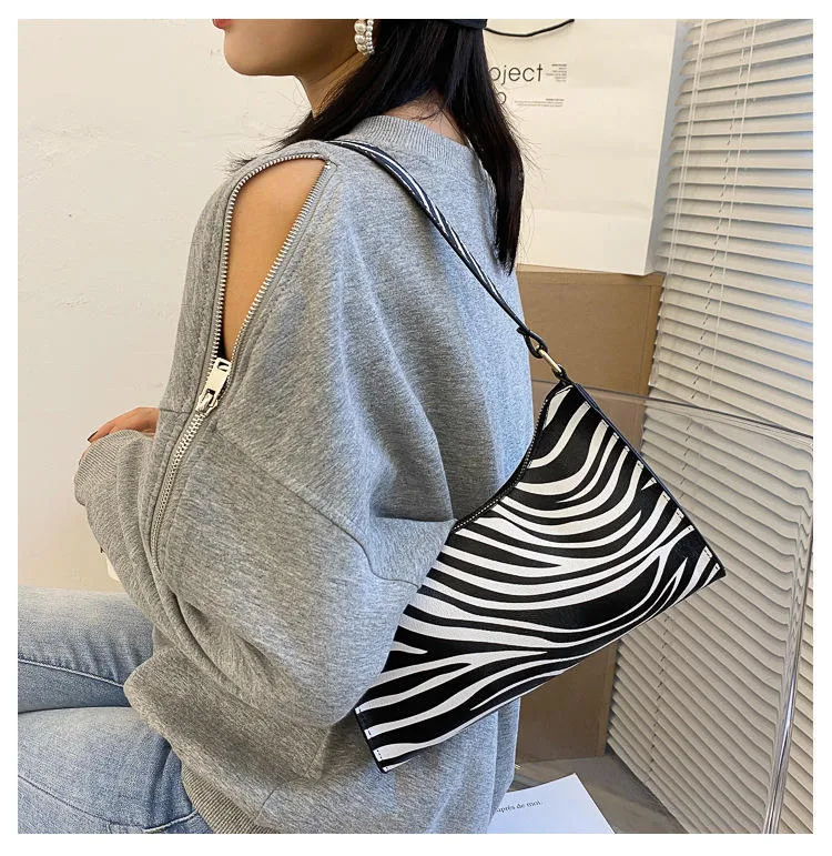 Leopard cow print underarm bag, a stylish and convenient accessory. Carry your essentials with ease and elegance, perfec