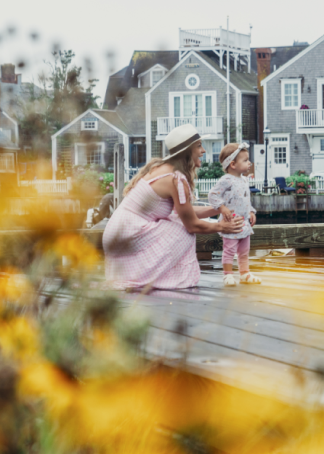 Collette Stohler crouched near hear child while on a boardwalk