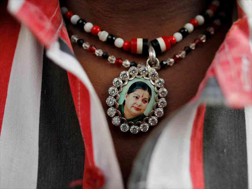 A supporter of Tamil Nadu Chief Minister Jayalalithaa Jayaraman wears a necklace with her picture as he attends a prayer ceremony at the AIADMK party office in Mumbai, India, December 6, 2016. /REUTERS