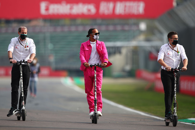 Lewis Hamilton rides a scooter during circuit previews.