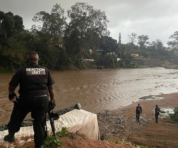 Reaction Unit members search for a herdsman and his cow who went missing as they tried to cross a raging river swollen by heavy rains on Tuesday