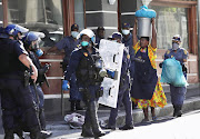 A refugee woman carries her belongings on her head as refugees are removed from the Methodist Church in Cape Town.