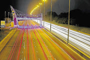 Hundreds of cars make their way home under one of the many e-toll gantries on the N1 motorway that runs around much of Johannesburg.