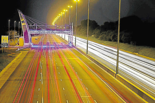 Hundreds of cars make their way home under one of the many e-toll gantries on the N1 motorway that runs around much of Johannesburg.