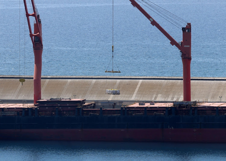 A crane lifts material onto a cargo vessel expected to take aid to Gaza from Cyprus, at the port of Larnaca, Cyprus, on May 8 2024.