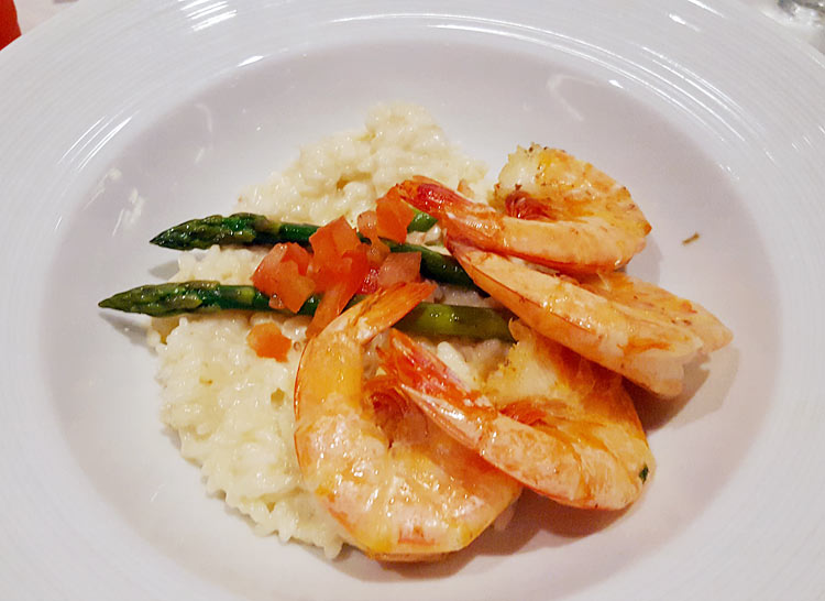 A crab meat and truffle risotto with shrimp and asparagus dish served in the main dining room on Harmony of the Seas.