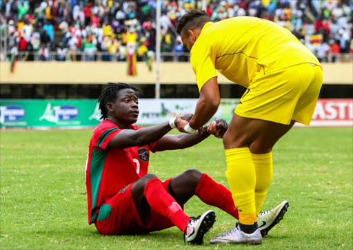 A file photo of Malawi's Joseph Kamwendo (L) shaking hands with Zimbabwe's Mathew Rusike at the end of an AFCON Group L qualifier football match between Malawi and Zimbabwe on June 5, 2016 at the National Sports Stadium in Harare.