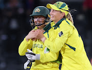 Alyssa Healy (left) and Meg Lanning of Australia celebrate after winning the 2022 ICC Women's Cricket World Cup final against England at Hagley Oval in Christchurch, New Zealand on April 3 2022.