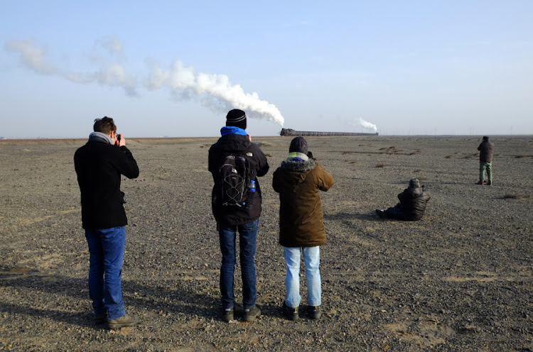 Foreign rail fans photograph a coal train on the Sandaoling Mining Railway in western China. PICTURE: Paul Ash