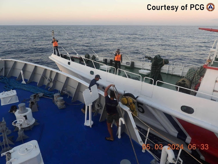 Philippine Coast Guard personnel inspect the hull of the ship during a collision incident between the Philippine Coast Guard vessel BRP Sindangan and a Chinese Coast Guard ship in the disputed South China Sea, March 5, 2024.