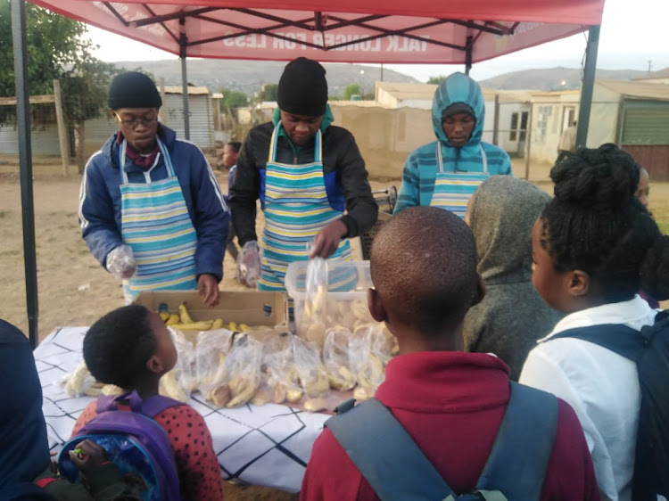 Jacob 'Mr Mayor' Madisha with members of his organisation who serve hungry children breakfast before they start their school day.