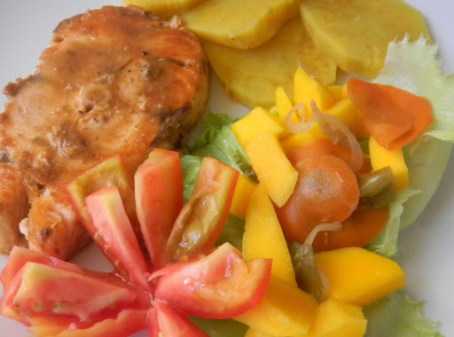 Vanillated Spicey Salmon served with boiled sweet potatoes, vegetable pickled mangoes on a bed of lettuce and salad tomatoes