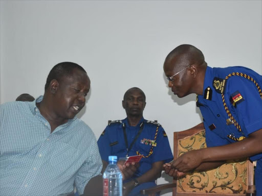 Interior CS Fred Matiang'i shows IG Joseph Boinnet the special ID card in Mombasa on Monday, January 21, 2019. /ANDREW KASUKU