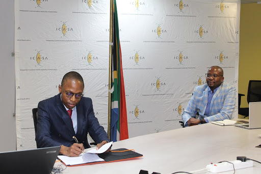 ICASA chairperson Dr Keabetswe Modimoeng (left) signing the MOU, while ICASA CEO Willington Ngwepe looks on.