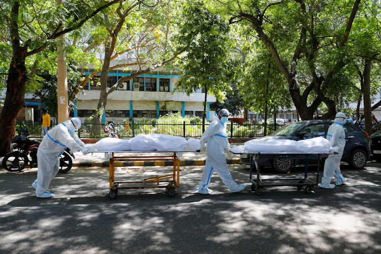 Health workers wearing personal protective equipment (PPE) carry bodies of people who were suffering from the coronavirus disease (Covid-19), outside the Guru Teg Bahadur hospital, in New Delhi, India, on April 24, 2021.